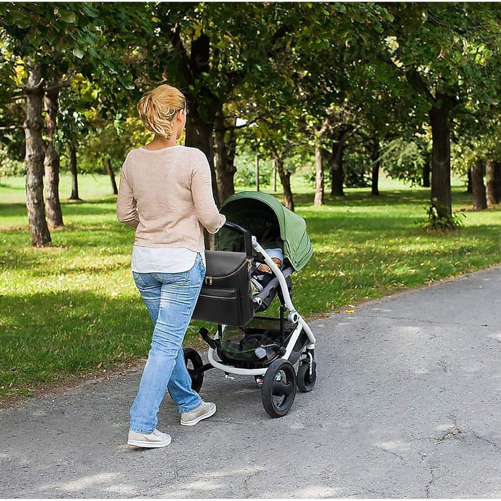 maman promène bébé à poussette avec sac a langer accroché