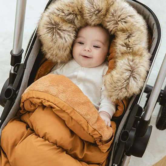 chanceliere bebe avec bébé souriant dans le col de fourrure