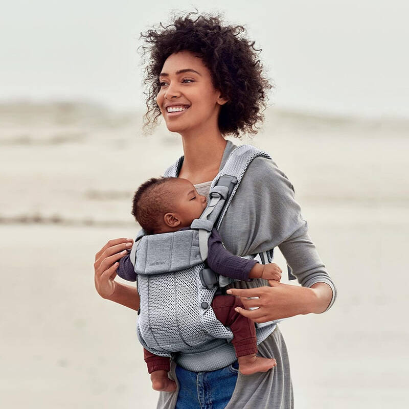 maman promène bébé sur la plage dans porte bébé harmonie