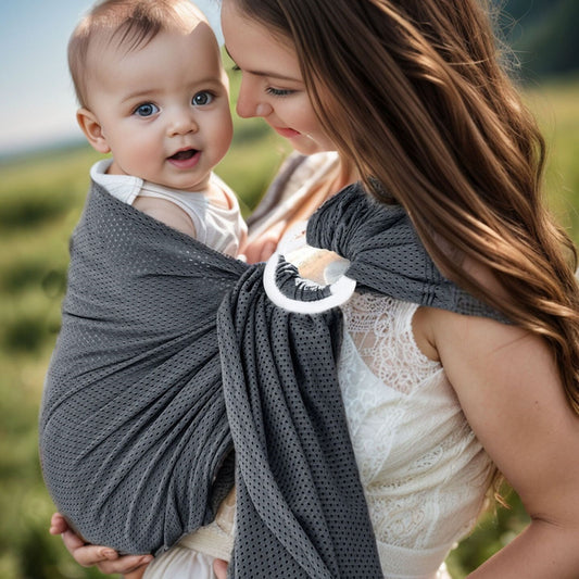 sling respirant gris où maman porte bébé dans un champ